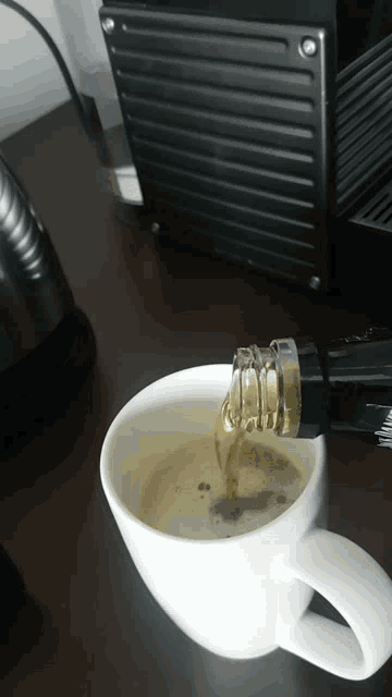 a bottle of coca cola is being poured into a white cup