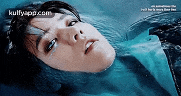 a woman is laying in the water with her eyes closed and tears coming out of her eyes .