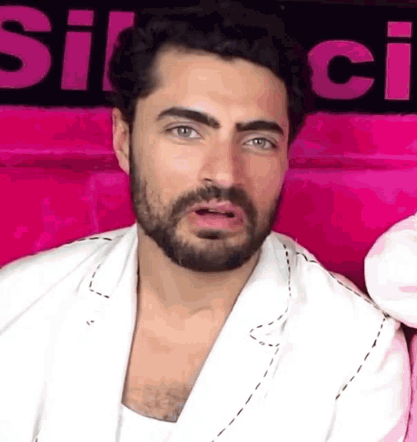 a man with a beard is wearing a white jacket