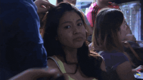 a woman with a surprised look on her face is in a crowd of people