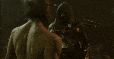 a man with a beard and a crown on his head is standing next to another man