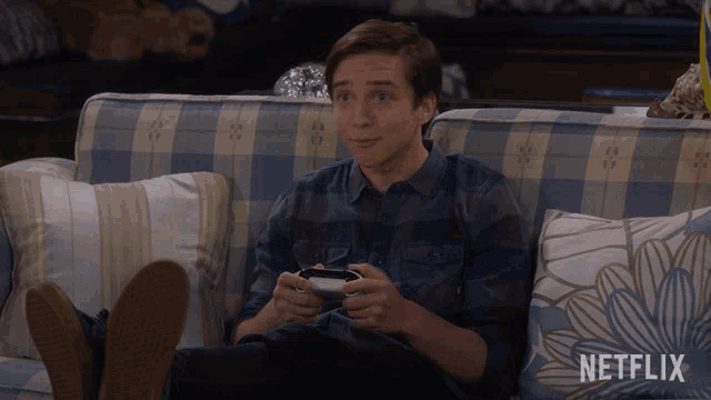 a man is sitting on a couch with a netflix logo on the bottom