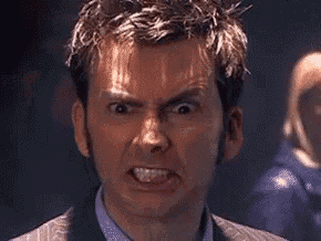 a man in a suit is making an angry face .
