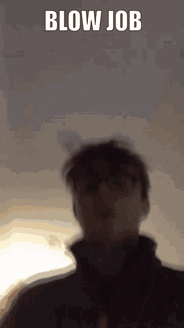 a blurry picture of a man 's face with the words blow job written above him .