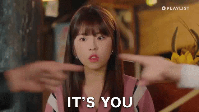 a woman is pointing at another woman 's face and saying it 's you .