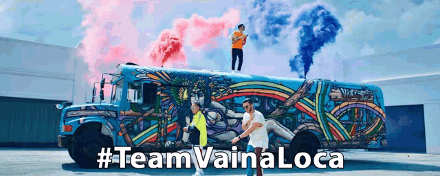 a man stands on top of a colorful bus with the words #team vaina loca written below him
