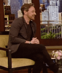 a man sits in a chair with his legs crossed