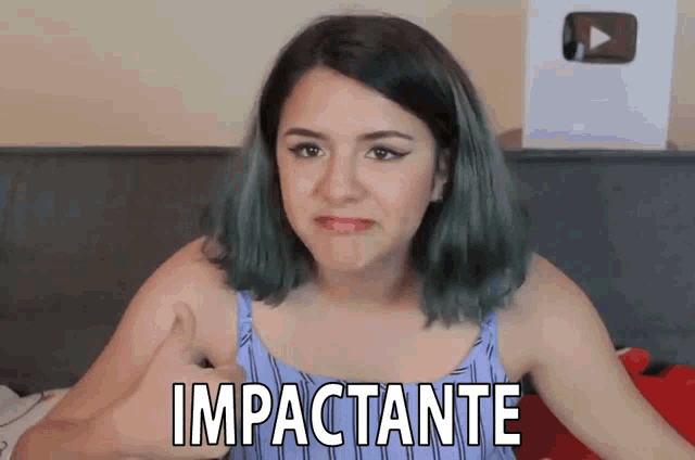 a woman with green hair is giving a thumbs up and the word impactante is above her head