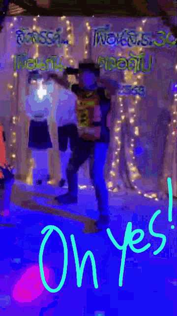 a man in a cowboy hat is dancing in front of a sign that says on yes .
