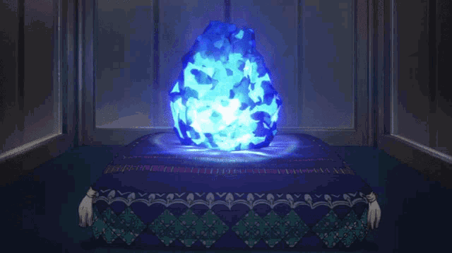 a blue glowing object is sitting on a blue blanket