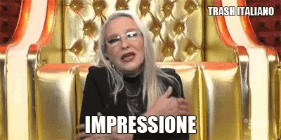 a woman with glasses is sitting in a chair with the word impressione written on the bottom .