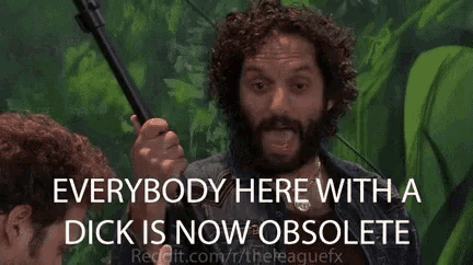 a man with curly hair and a beard is holding a stick and saying everybody here with a dick is now obsolete