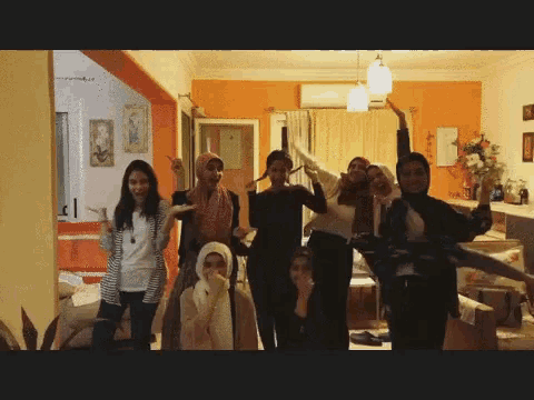 a group of young women are posing for a picture in a living room