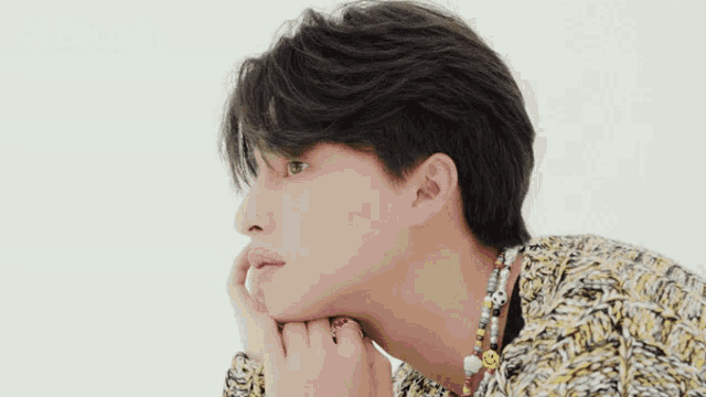 a close up of a man 's face with his hand on his chin and the words x blush behind him .