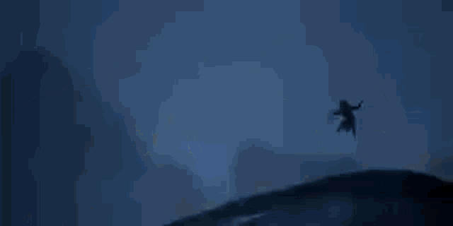a person is laying on their back in the dark with their head down .