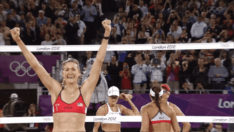 a woman in a red top with the letter f on it stands in front of a net that says london 2012