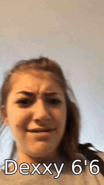 a girl is making a funny face with the words `` dexxy 6 '6 '' on her face .