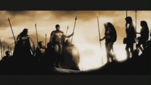 a group of soldiers standing on top of a hill holding spears