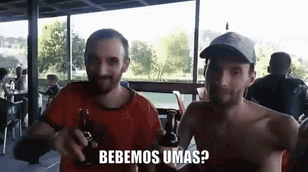 two shirtless men are holding bottles of beer and one of them is asking " bebemos umas ? "