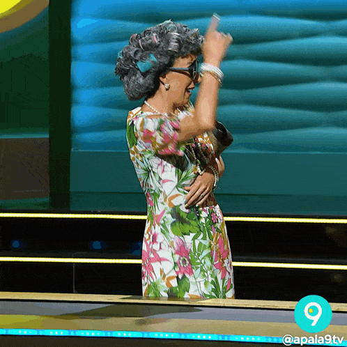 a woman in a floral dress giving the middle finger with the number 9 in the corner