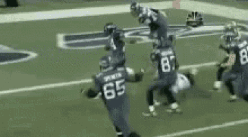 a football player with the number 65 on his jersey runs on the field