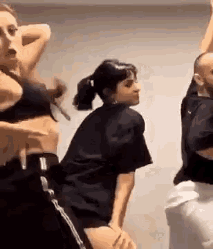 three people are dancing together in a room .
