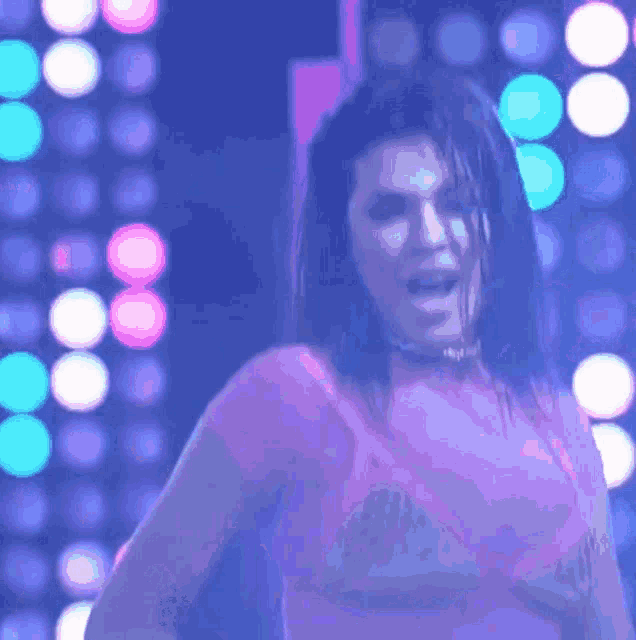 a woman in a pink top is dancing on a stage