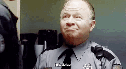 a man in a police uniform and tie is making a funny face and saying okiedokie .