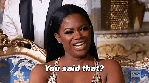 a woman is sitting on a couch and smiling and saying `` you said that ? ''