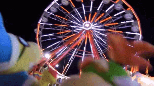 a ferris wheel at an amusement park at night with a circle in the middle