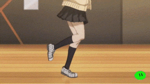 a girl in a skirt and black socks is walking on a wooden floor