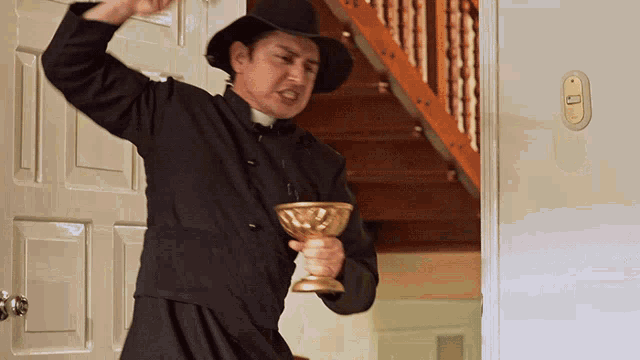 a priest is holding a golden chalice in his hand