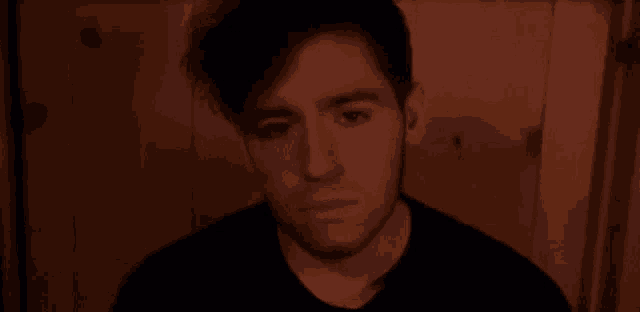 a close up of a man 's face with his eyes closed in a dark room .