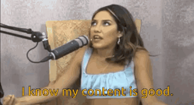 a woman is sitting in front of a microphone and saying i know my content is good