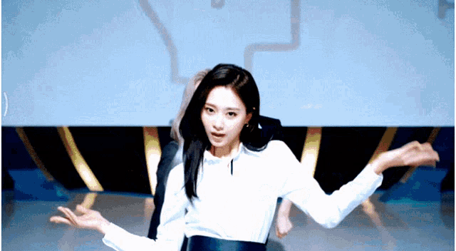 a woman in a white shirt is dancing with her hands outstretched
