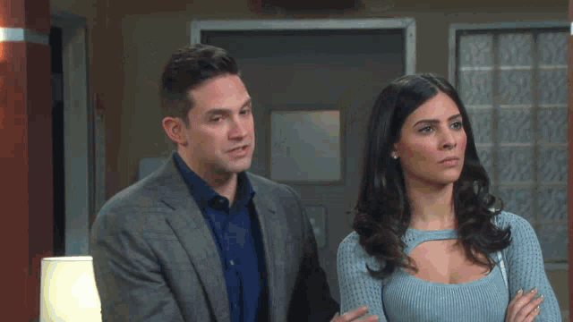 a man and woman are standing next to each other in a room