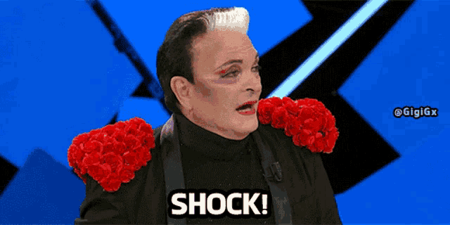 a man with red roses on his shoulders is saying shock