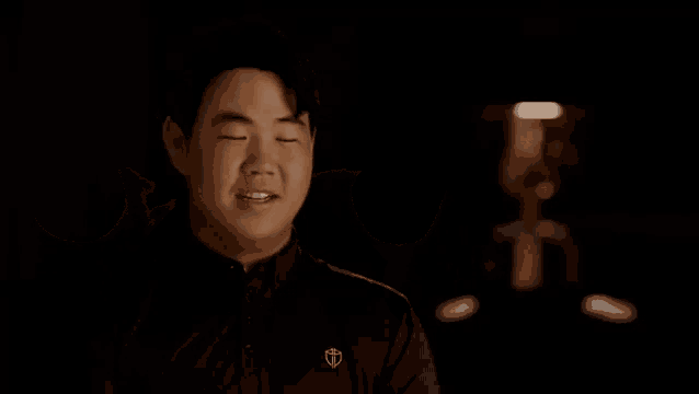 a man is covering his eyes with his hands in a dark room .