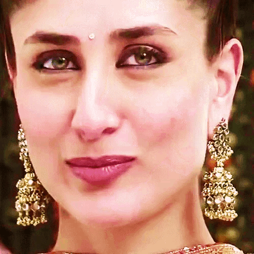 a close up of a woman wearing gold earrings