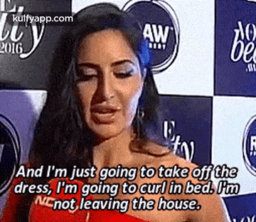 a woman in a red dress is talking on a red carpet and i 'm just going to take off the dress .
