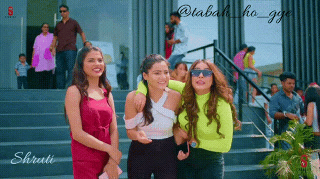 three women are standing on a set of stairs with the words shruti on the bottom right