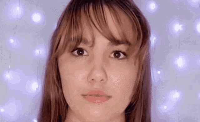 a close up of a woman 's face with a purple background .