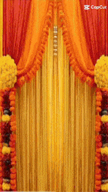 a yellow and red curtain with flowers hanging from it .