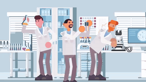 a group of scientists are standing in a lab with their arms in the air .