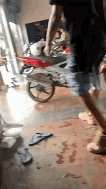 a man is walking towards a motorcycle in a garage .