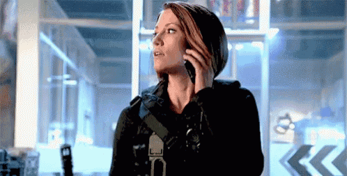 a woman is talking on a cell phone while standing in a room .