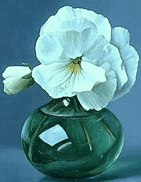a white flower is sitting in a green vase .