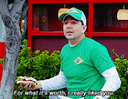 a man in a green shirt is holding a sandwich and saying for what it 's worth