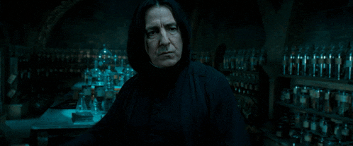 a man holding a wand in a dark room with many bottles