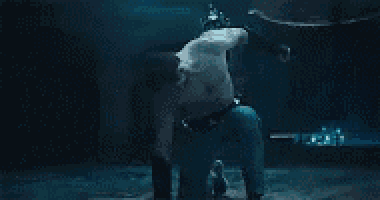 a man is kneeling down with a chain around his neck .